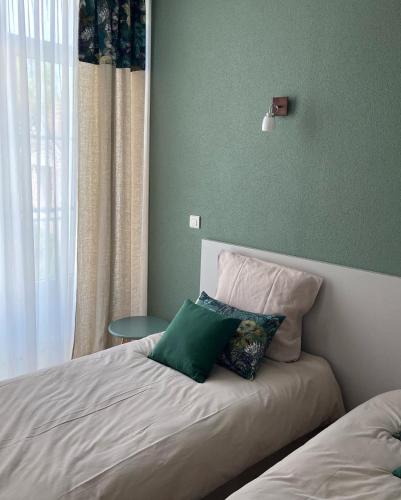 a bed with two pillows on it in a bedroom at La Rose des vents in Saint-Symphorien-de-Marmagne