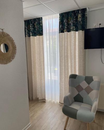 un salon avec une chaise et une fenêtre dans l'établissement La Rose des vents, à Saint-Symphorien-de-Marmagne