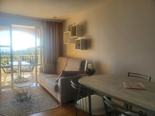 un salon avec un canapé et une table dans l'établissement Village Cap Estérel Agay St Raphaël vue mer et piscine, à Agay