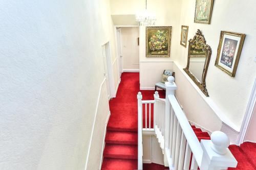 a red carpeted staircase in a home with white walls at Walcot Hall - Stunning Stately Home set in 27 acres of parkland and sleeping 16+ in Alkborough