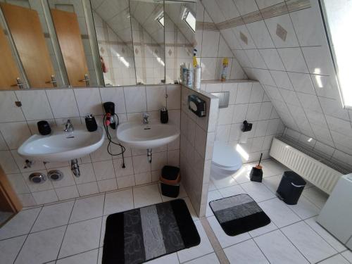 a bathroom with two sinks and a toilet at Apartment Linss in Gebesee