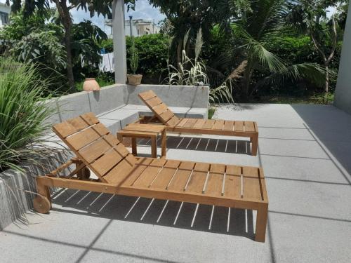 two wooden chairs and a bench on a patio at Villa Soforal in Cap Skirring