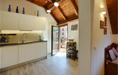 a kitchen with white cabinets and a wooden ceiling at Nice Apartment Santo Stefano in Santo Stefano dʼAveto