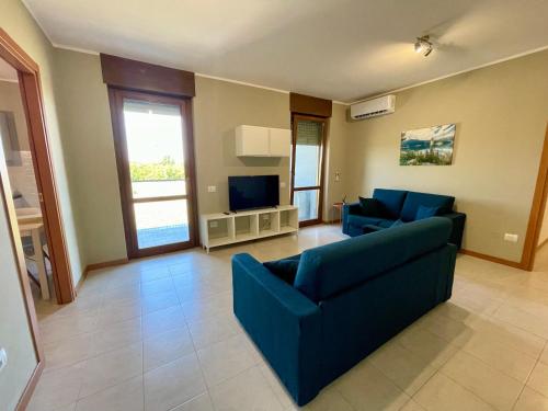ein Wohnzimmer mit zwei blauen Sofas und einem TV in der Unterkunft Appartamento Giglio in Mantua