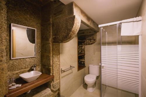 a bathroom with a sink and a toilet and a shower at Hospederia Tarela in Santiago de Compostela