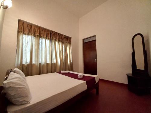 um quarto com uma cama grande e uma janela em Lazy Bear Best Hostel in Kandy em Kandy