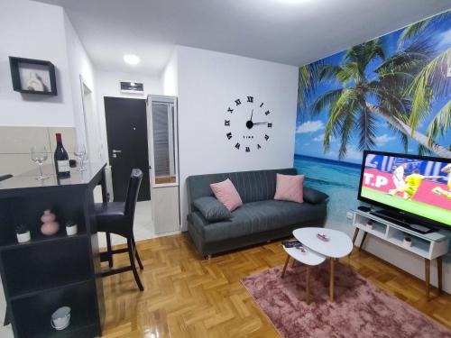 ein Wohnzimmer mit einem Sofa und einer Uhr an der Wand in der Unterkunft RELAX in Požarevac