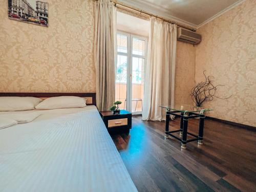 a bedroom with a bed and a glass table at Квартира в центре Крещатика in Kyiv