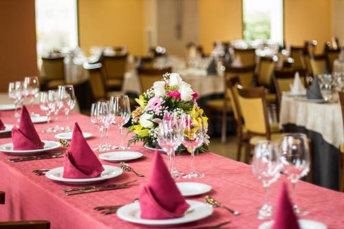 a table with pink napkins and flowers on a table at Hotel Abades Guadix in Guadix