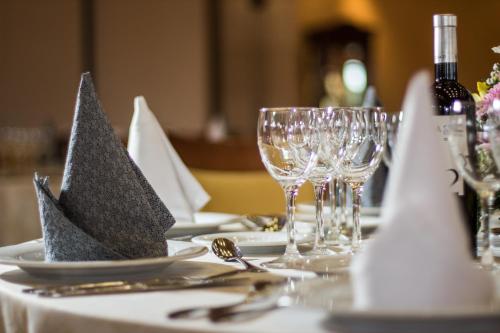 a table with plates and wine glasses and napkins at Hotel Abades Guadix in Guadix