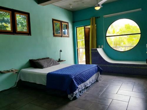 a bedroom with a bed and a round window at Lote 44 Guesthouse in El Zonte