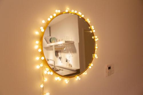 a mirror with christmas lights on a wall at Hostel Mihojae Seomyeon in Busan
