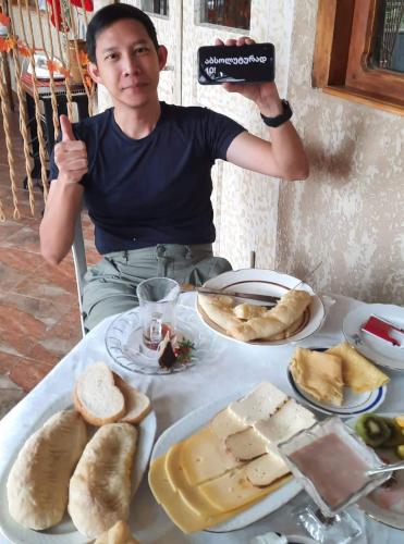 a man taking a picture of a table of food at Gantiadi in Kutaisi