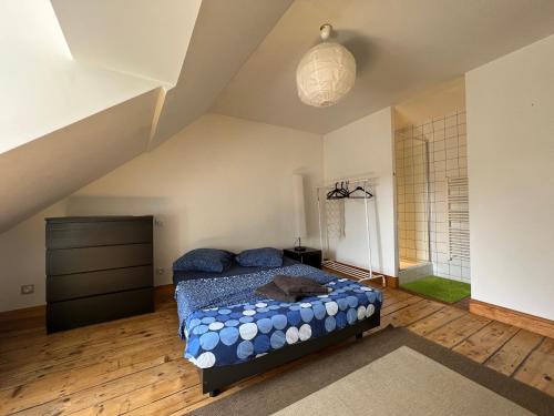 een slaapkamer met een bed met blauwe kussens erop bij Pépite au plein centre historique in Lons-le-Saunier