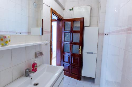 a bathroom with a sink and a shower and a door at Kaplan Cosy Flat - All air conditioned & Heated 3 Bedrooms in the City in Istanbul