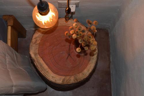 a wooden table with a vase of flowers on it at Cabañas Sixilera in Huacalera