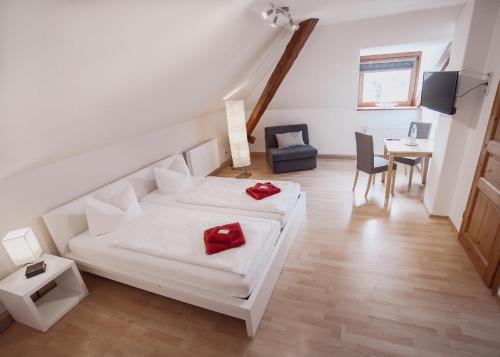 a bedroom with a white bed and a table and chairs at Hotel Am Rittergut in Frankenberg