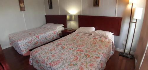 Habitación de hotel con 2 camas y 2 lámparas en Regal Motel, en Timmins