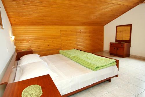 a bedroom with a bed and a wooden wall at Apartments with parking space Novalja, Pag - 9419 in Novalja
