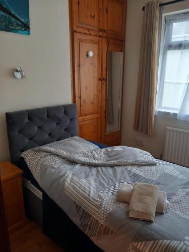um quarto com uma cama com uma cabeceira e uma janela em Home Comforts em Castleisland