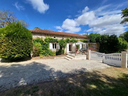 a small house with a white fence in front of it at La petite Maison in Ronsenac