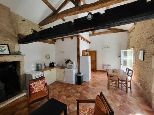 une cuisine et une salle à manger avec une table et des chaises dans l'établissement La petite Maison, à Ronsenac