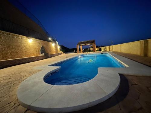 una piscina nel mezzo di un edificio di notte di Doña Ana ad Almogía