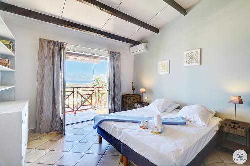 a bedroom with a bed with a view of the ocean at Villa Horizon Lagon - Piscine chauffée - Vue Mer - 4étoiles - 130m2 - 8p in La Saline les Bains