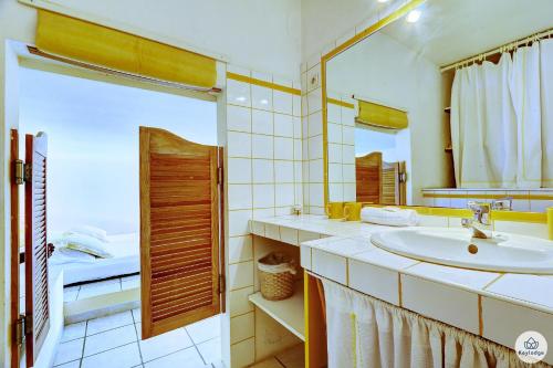 a bathroom with a sink and a mirror at Villa Horizon Lagon - Piscine chauffée - Vue Mer - 4étoiles - 130m2 - 8p in La Saline les Bains