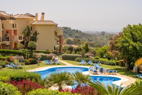 a villa with a swimming pool and a resort at LOS ARQUEROS GOLF APARTMENTS in Benahavís