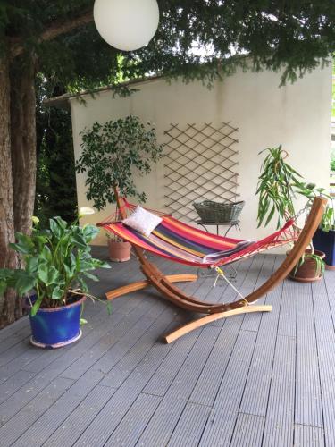 a hammock sitting on top of a deck at Vacances révées au Pin Parasol in Le Thor