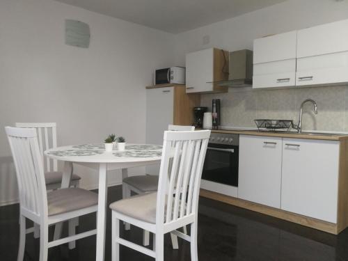 een keuken met een tafel en stoelen en een wastafel bij Apartment Smoljanac 12345c in Smoljanac