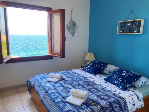 een blauwe slaapkamer met een bed met handdoeken erop bij Apartmán Panoramico in Costa Paradiso