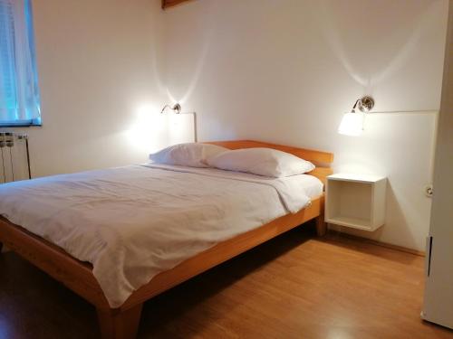 a bedroom with a bed with two lights on it at Apartments with a parking space Smoljanac, Plitvice - 14979 in Smoljanac