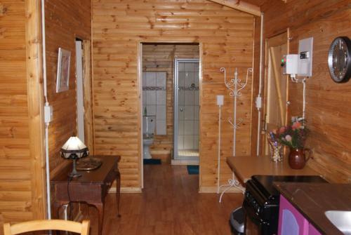 - un salon avec des murs en bois et du parquet dans l'établissement Fern Cottage, à Louis Trichardt