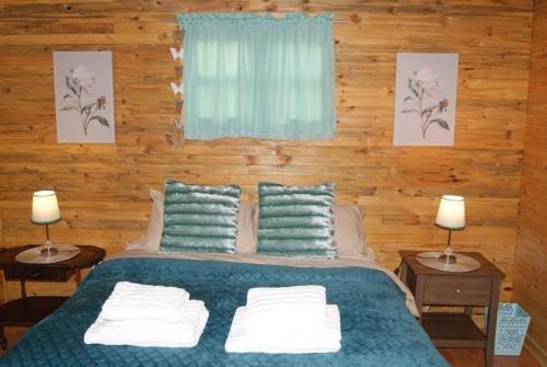 - une chambre avec un lit, 2 tables et 2 lampes dans l'établissement Fern Cottage, à Louis Trichardt