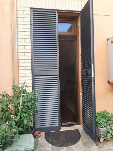 een zwarte luiken deur die naar een huis leidt bij Appartamento privato accanto studi televisivi in Rome