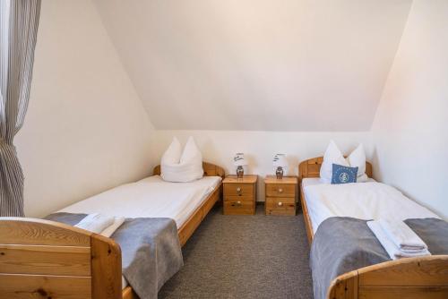 two twin beds in a small room with two tables at Seehaus Juist in Juist