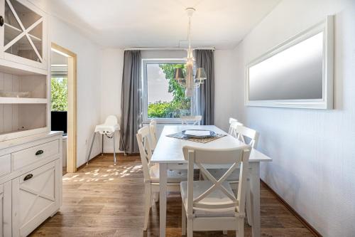 a kitchen and dining room with a white table and chairs at Seehaus Juist in Juist