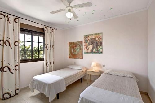 a bedroom with two beds and a window at Casa Fañabé Precioso adosado in Adeje