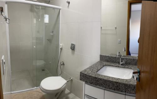 a bathroom with a toilet and a sink and a shower at Confort Flats in Bonito