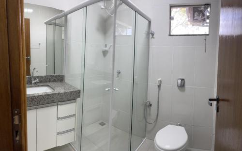 a bathroom with a shower and a toilet and a sink at Confort Flats in Bonito
