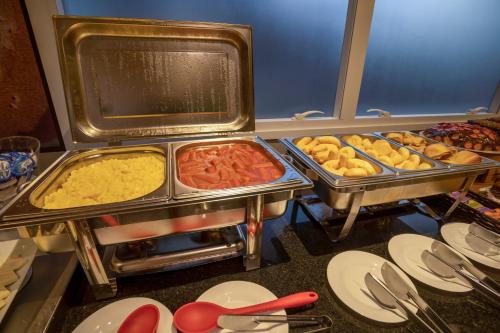 un buffet con muchos tipos diferentes de comida en bandejas en Carandá Hplus Express, en Campo Grande