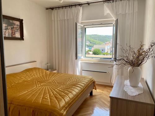 a bedroom with a bed and a window at Apartment Olga in Pučišća