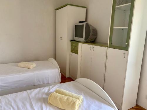 a room with two beds and a tv and a mirror at Apartment Olga in Pučišća