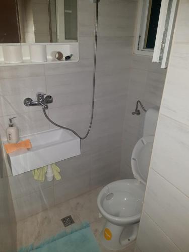 a white bathroom with a toilet and a sink at Studio Dinjiska 9386a in Povljana