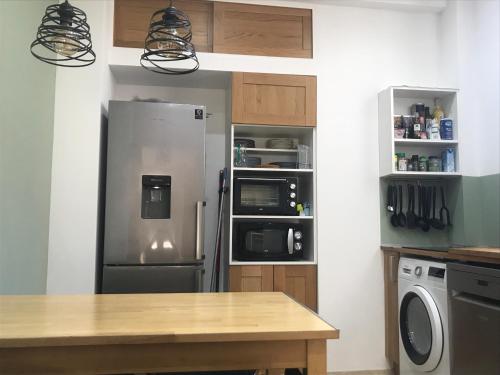 une cuisine avec un réfrigérateur en acier inoxydable dans l'établissement Très bel appartement T3 proche place Castellane avec vue et 2 chambres, à Marseille