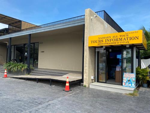 a building with a yellow sign on the front of it at The Gallery Hotel Nai Harn in Nai Harn Beach