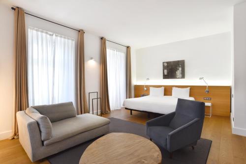 a hotel room with a bed and a couch and a chair at Hotel Zenit Budapest Palace in Budapest