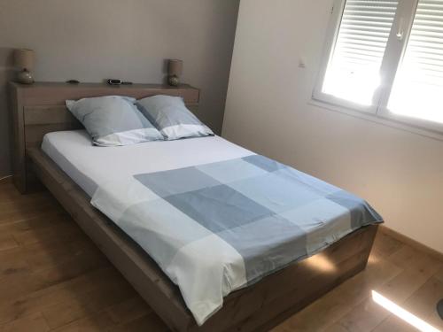 uma cama com um edredão azul e branco num quarto em Très bel appartement T3 proche place Castellane avec vue et 2 chambres em Marselha